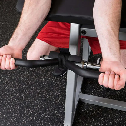 Mann trainiert mit Hantelbank und Kurzhantel im Fitnessstudio – Krafttraining Equipment