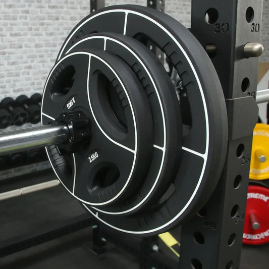 2,5 kg Hantelscheiben mit weißer Linie auf Langhantel im Kraftstation-Setup für Homegym Training