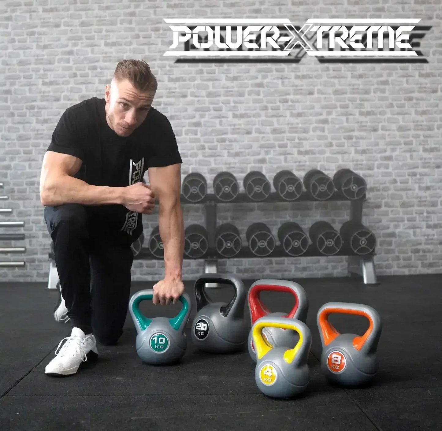 Muskulöser Mann mit Kettlebells in Fitnessstudio, Power-Xtreme Equipment für Krafttraining und Homegym
