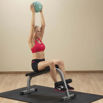 Frau trainiert mit Medizinball auf Hantelbank – Fitness-Kraftgeräte für Homegym & Studio