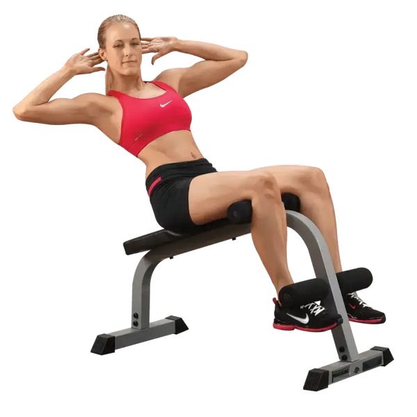 Frau macht Bauchmuskelübungen auf Hantelbank mit Fußhalterung für Homegym-Training