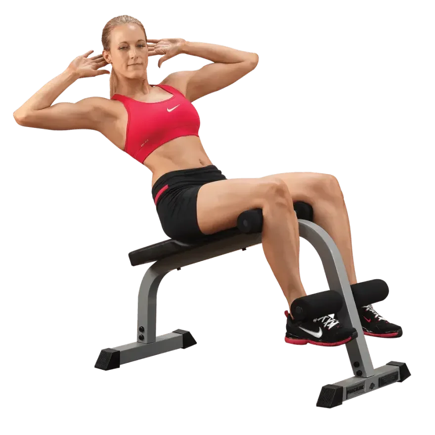 Frau macht Bauchmuskelübungen auf Hantelbank mit Fußhalterung für Homegym-Training