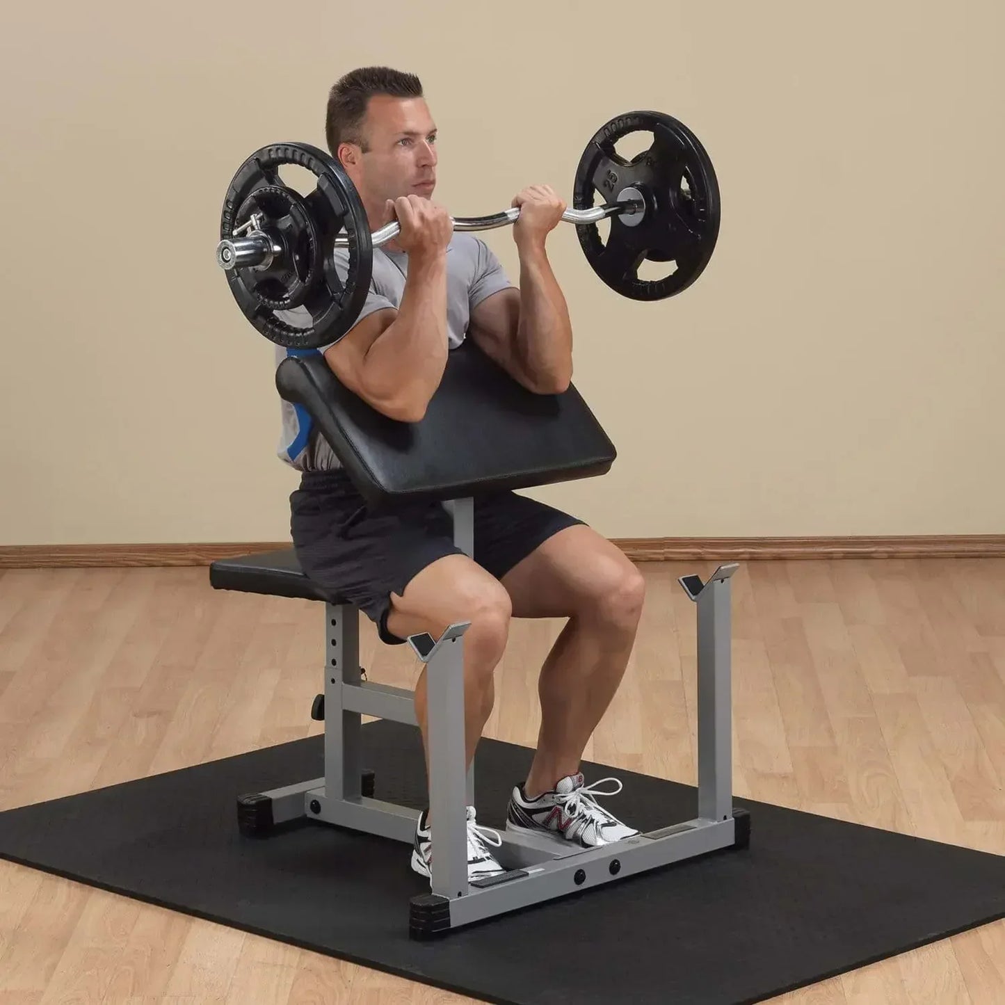Mann trainiert mit Langhantel auf Hantelbank für Bizeps-Curls im Homegym