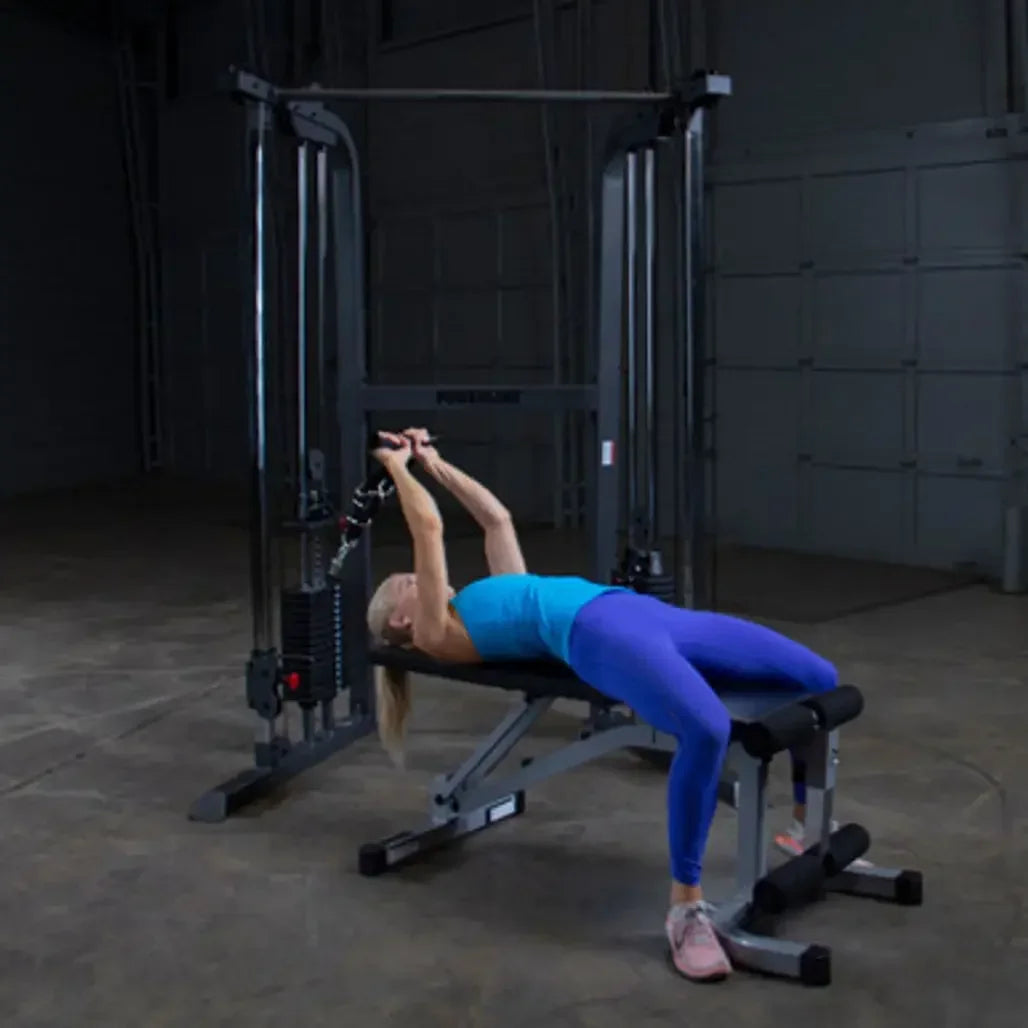 Frau trainiert an Kraftstation mit Hantelbank im Homegym – Fitness-Kraftgeräte für effektives Training