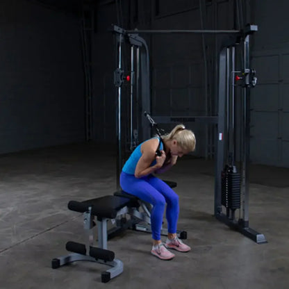 Frau trainiert an Kraftstation mit Hantelbank im Homegym – Fitness-Kraftgeräte für effektives Training