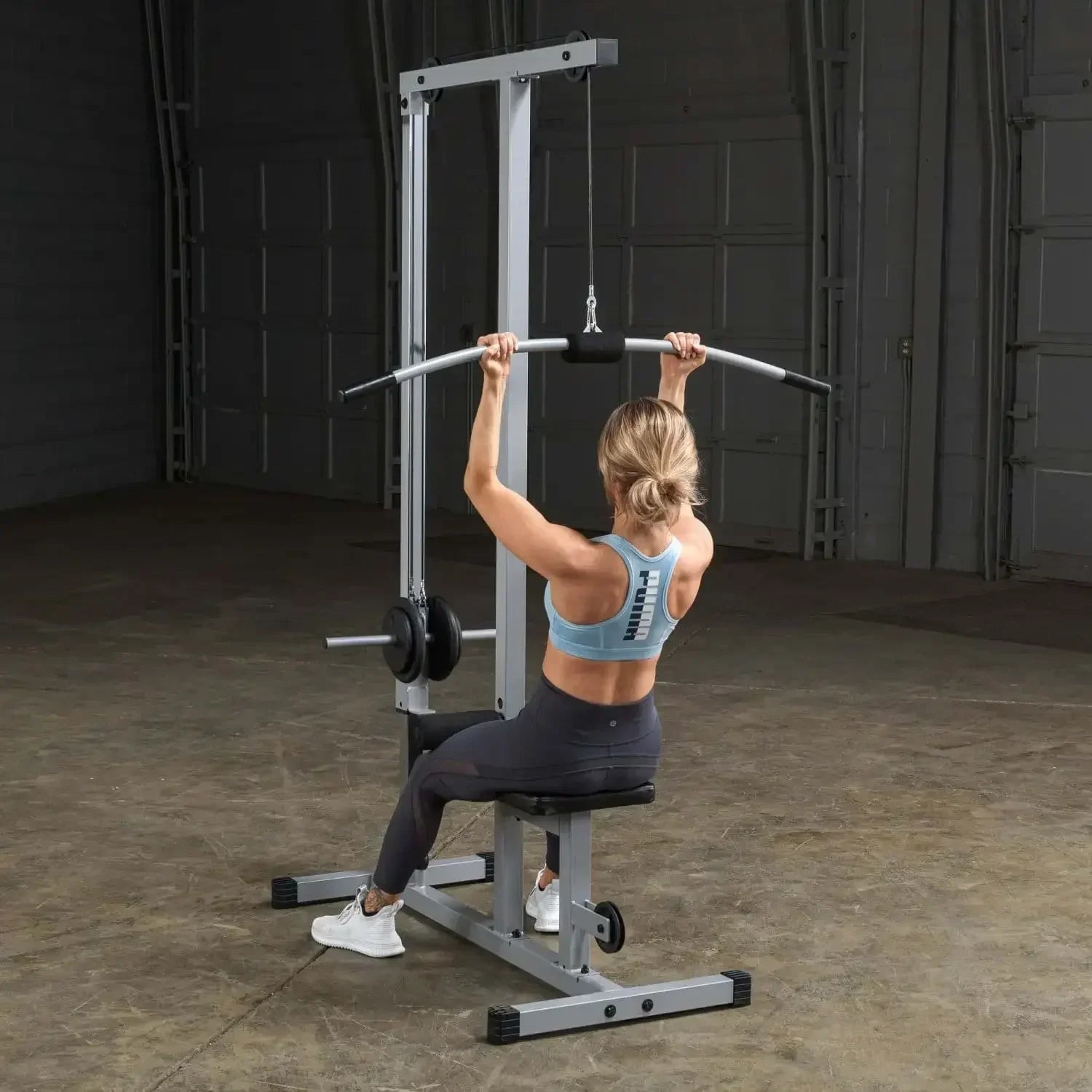 Frau trainiert an Kraftstation mit Latzug für Homegym und Studio, Fitness-Kraftgeräte