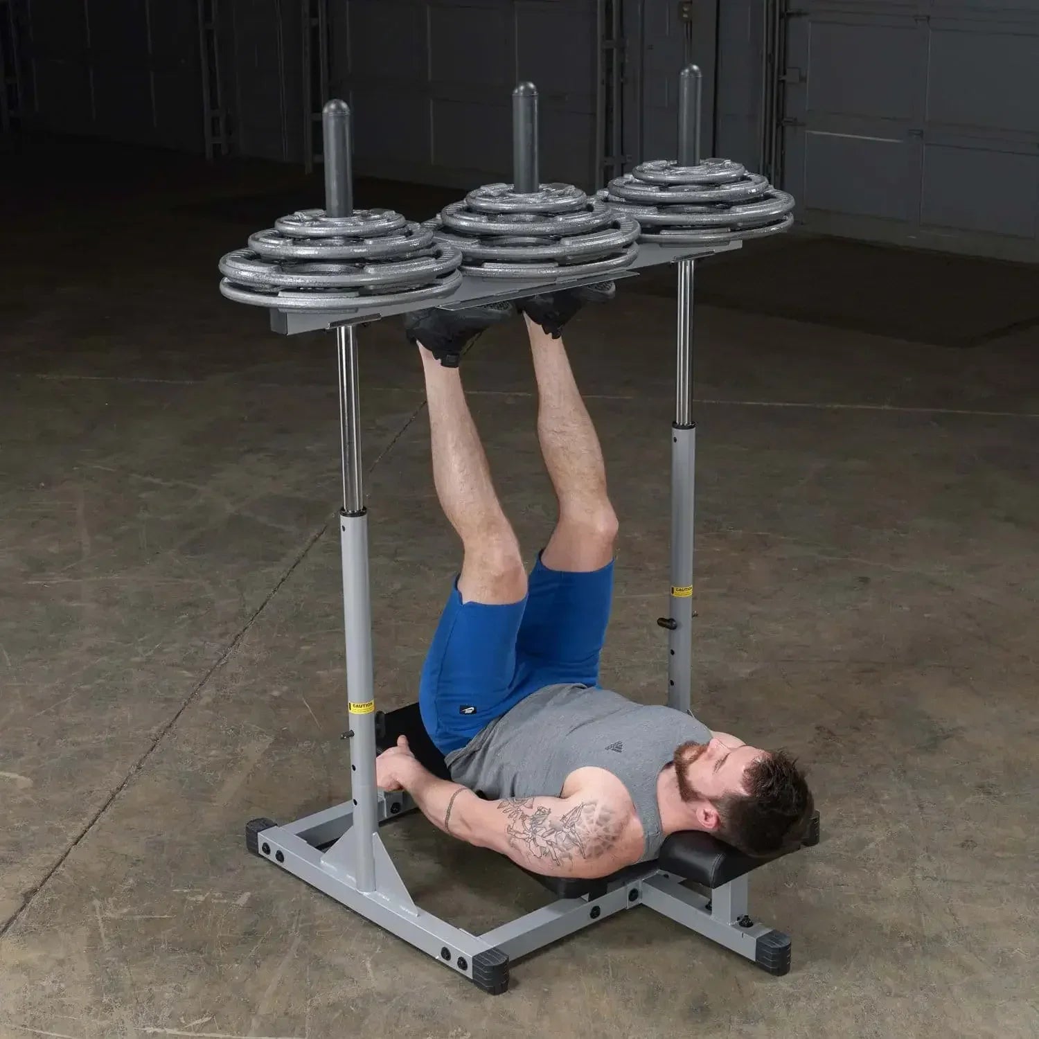 Mann trainiert Beine mit Hantelbank und Gewichtsstation im Homegym