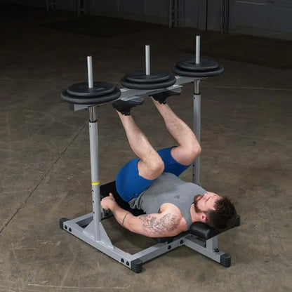 Mann trainiert Beine mit Hantelbank und Gewichten im Fitnessstudio