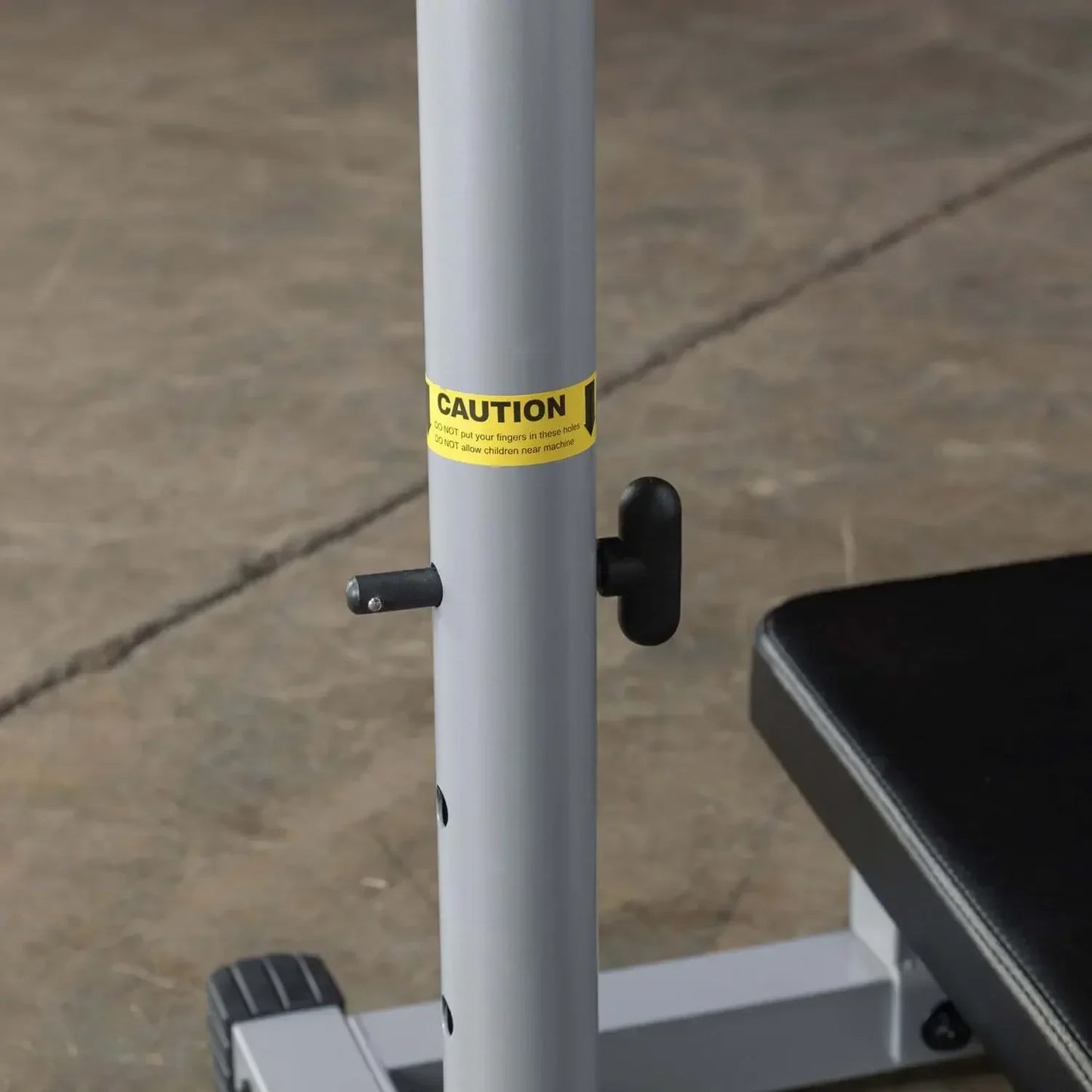 Kraftstation mit Sicherheitshinweis: CAUTION-Aufkleber an grauem Ständer, ideal für Homegym & Fitnessstudio