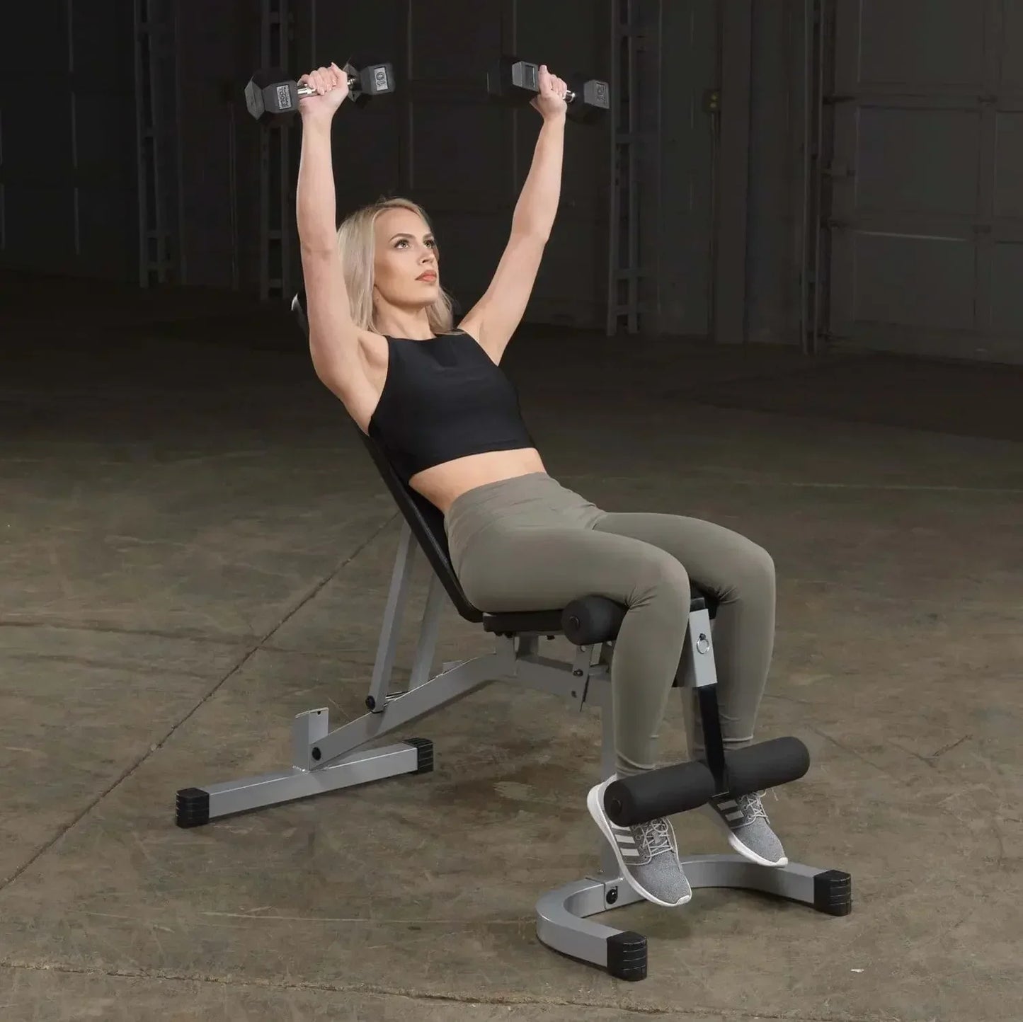 Frau trainiert mit Hanteln auf Hantelbank im Fitnessstudio, ideal für Homegym & Krafttraining