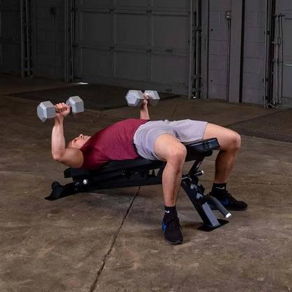 Mann trainiert mit Hanteln auf Hantelbank im Homegym – Kraftsport & Fitness Equipment