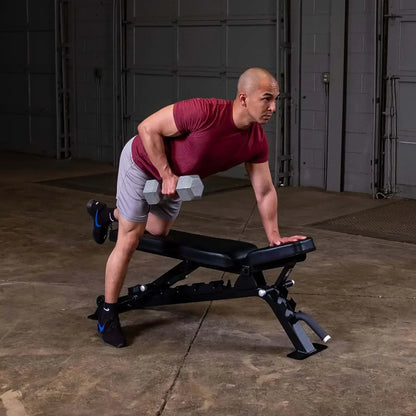 Mann trainiert mit Hanteln auf Fitnessbank im Homegym – Kraftsport & Fitness Equipment