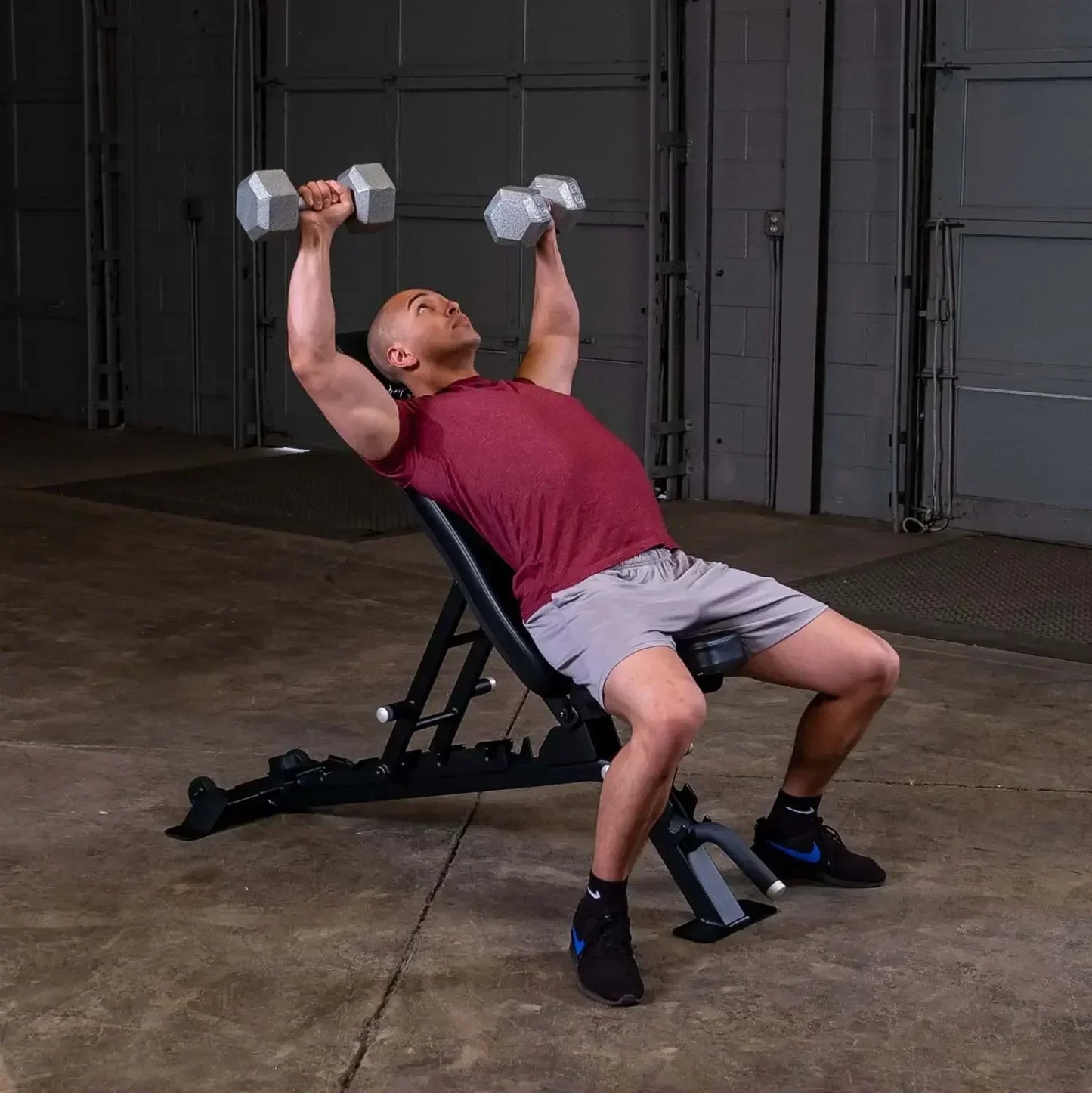 Mann trainiert mit Hanteln auf Hantelbank im Homegym – Kraftsport & Fitness Equipment