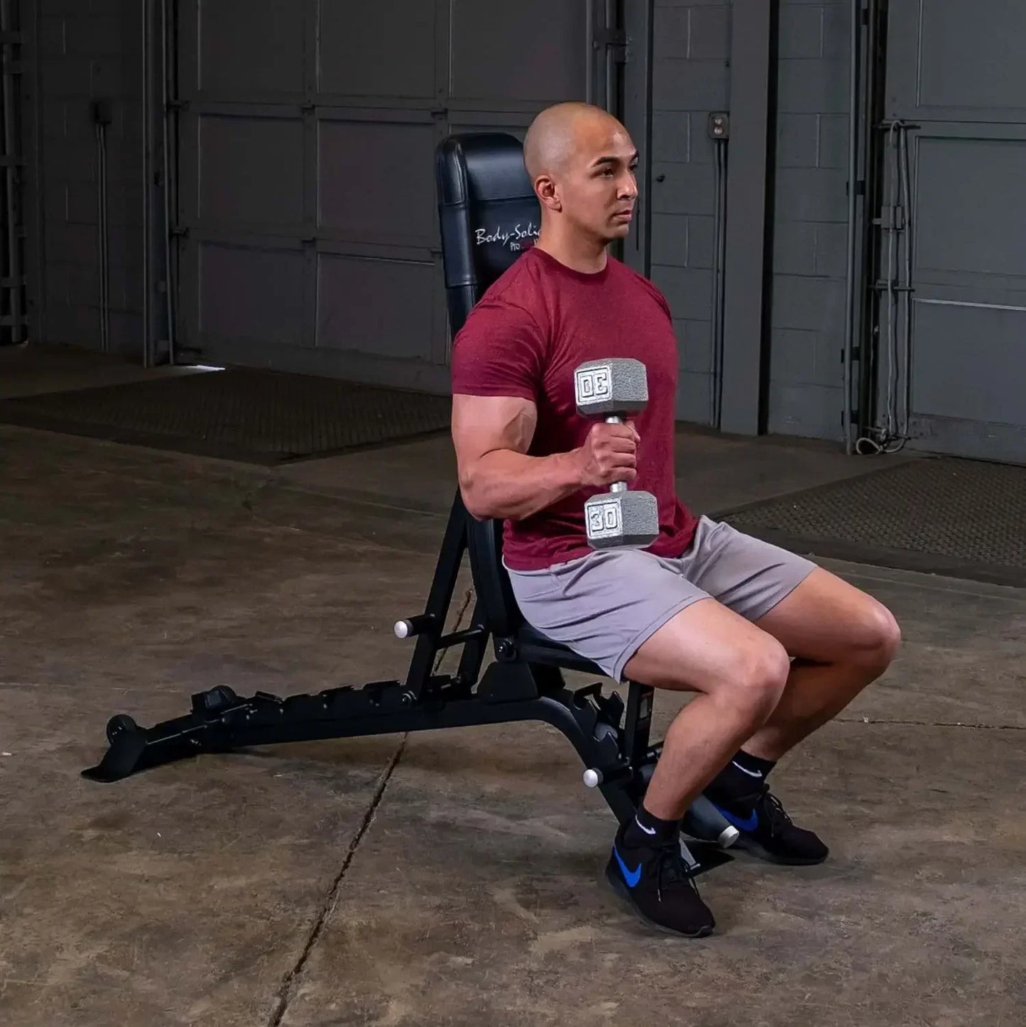Mann trainiert mit Hantel auf Hantelbank im Homegym – Kraftsport & Fitness Equipment