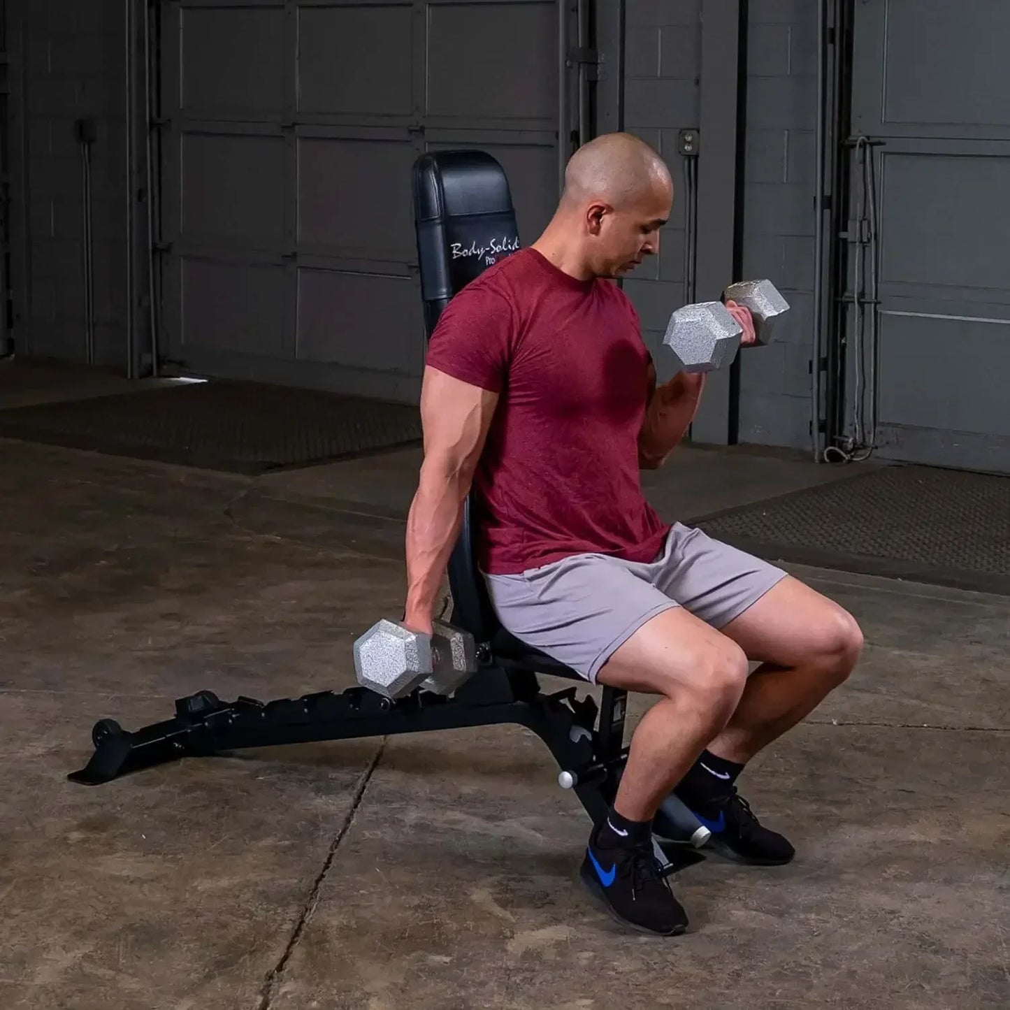 Mann trainiert mit Hanteln auf Hantelbank im Homegym – Krafttraining mit Profi-Equipment