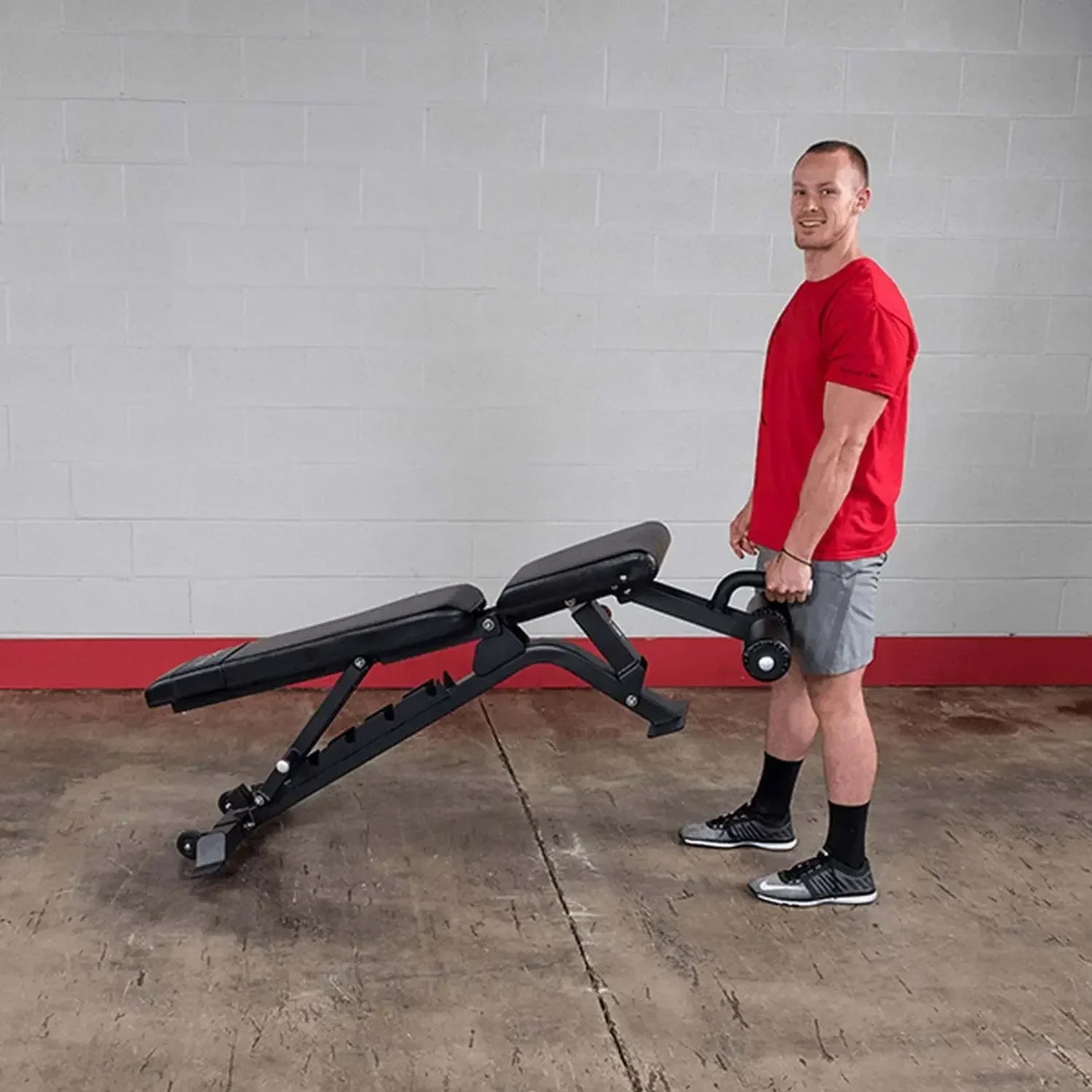 Mann mit Hantelbank im Fitnessstudio – ideale Trainingsbank für Homegym & Studio