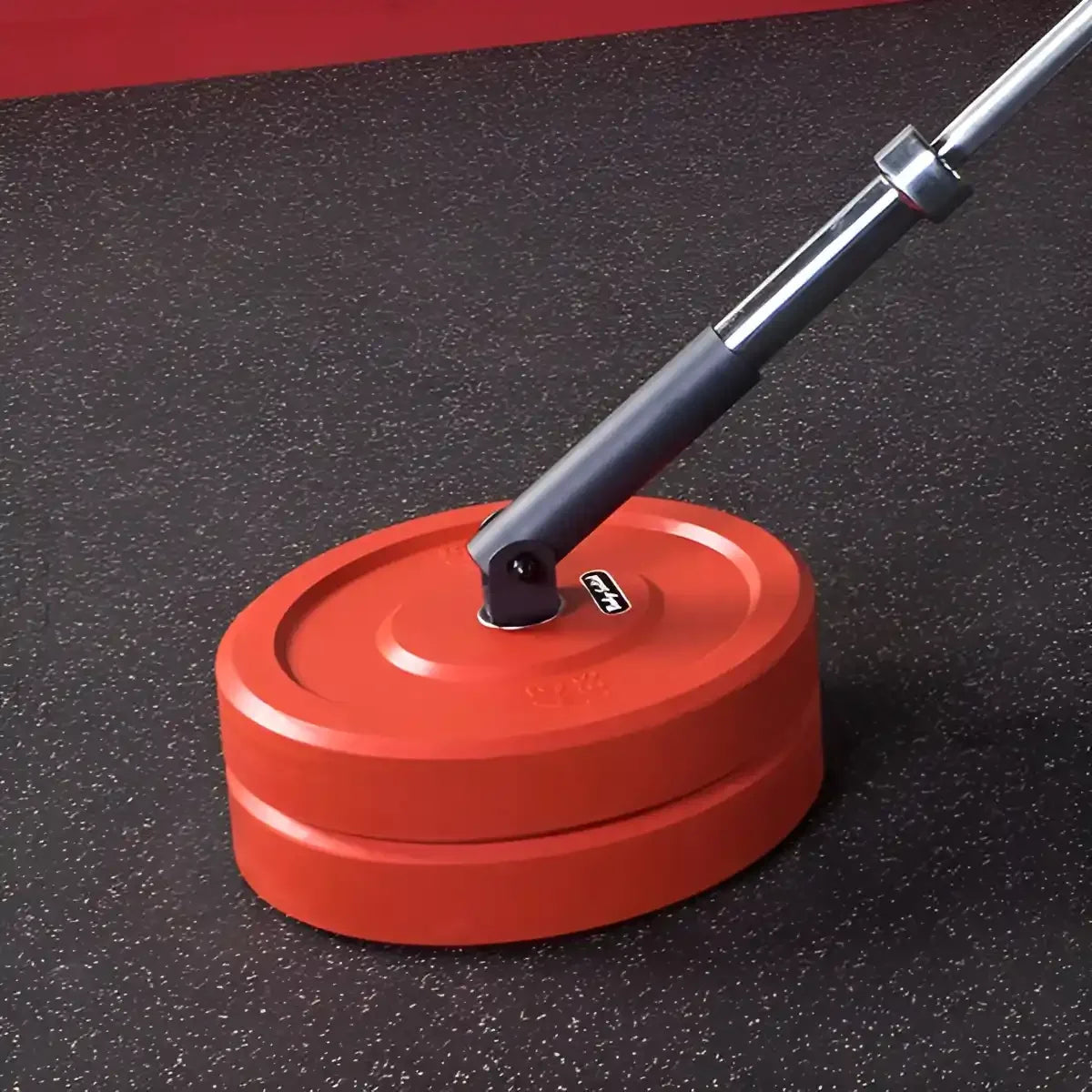 Rote Hantelscheiben mit Langhantel auf Fitnessboden für Krafttraining
